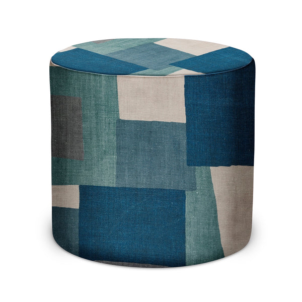 Round indoor pouf with blue and gray patchwork collage fabric, flat top