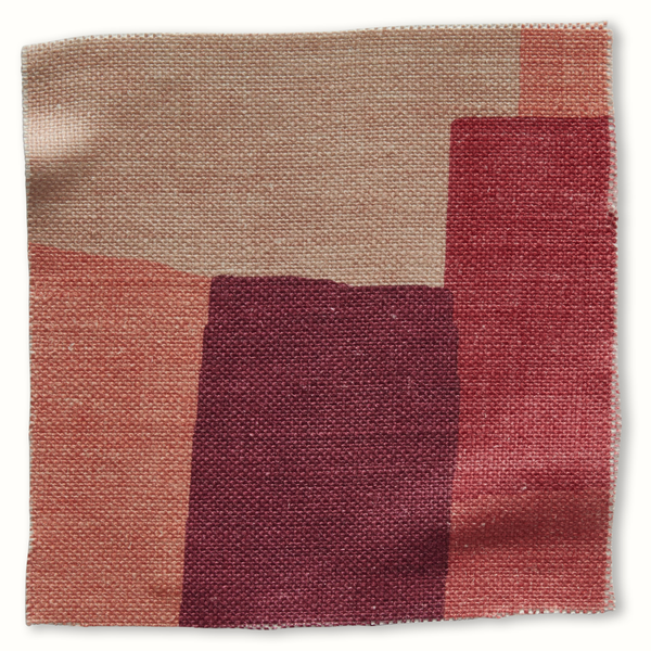 Coral and pink patchwork pillow cover with geometric fabric blocks in burgundy and red
