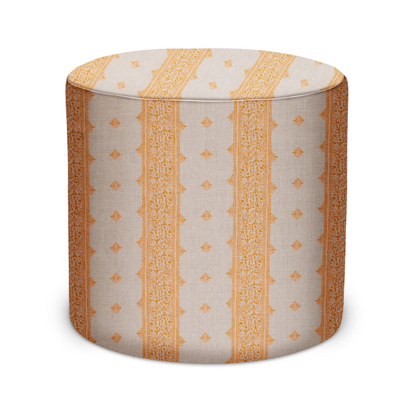 Indoor pouf with cylindrical shape, gold and natural geometric patterned fabric.