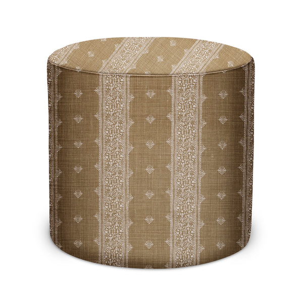 Round indoor pouf upholstered in bronze textured fabric with vertical patterned panels