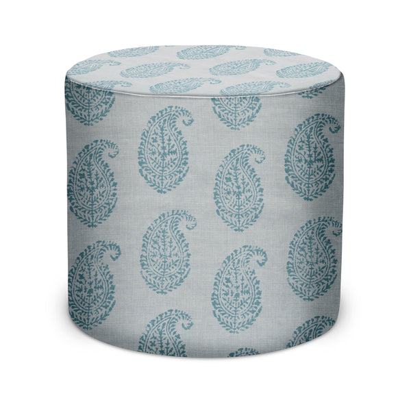 Cylindrical upholstered pouf with blue paisley pattern on light fabric