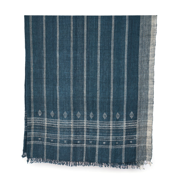 Indigo bedcover with vertical stripes, diamond motifs near hem, fringed border