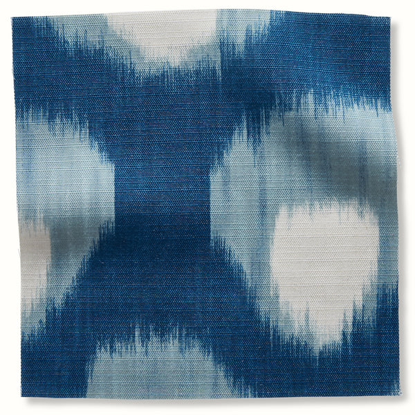 Blue outdoor pillow cover fabric with abstract ikat-style pattern in light blue and white