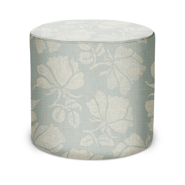 Round upholstered pouf in light ocean blue with natural botanical print and trim