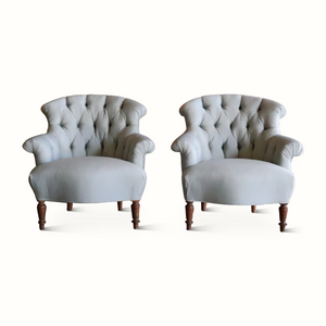 Set of 2 tufted Napoleon chairs with light blue upholstery, curved arms, and dark wood base
