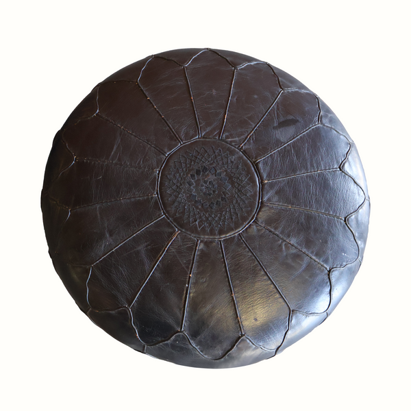 Round ottoman top close-up with dark brown tufted leather and embossed rosette pattern