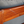 Wooden armchair close-up: reddish-brown armrest rail with light blue cushion