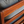 Wooden armchair close-up: light blue cushion beside reddish-brown frame