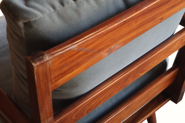 Wooden armchair close-up: light blue cushion beside reddish-brown frame