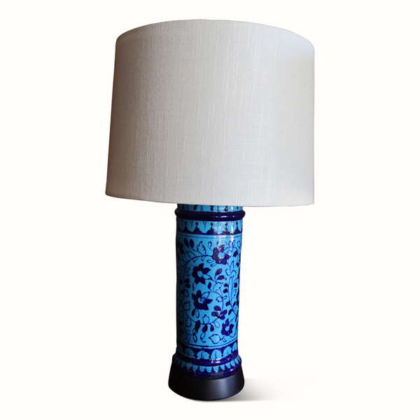 Blue Persian pottery table lamp with white fabric shade and dark pedestal base