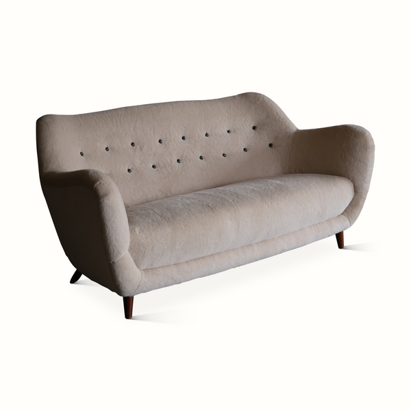 Light gray upholstered sofa with rolled arms and button-tufted back, dark legs.