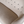 Close-up of light gray sofa upholstery with button-tufted back and smooth seat cushion.
