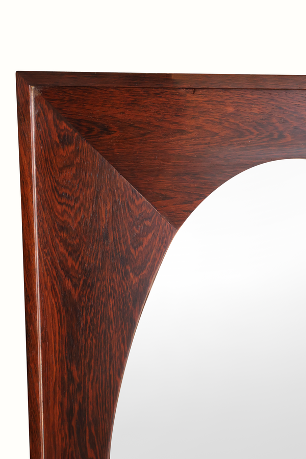 Close-up of Italian rosewood mirror frame edge with oval glass corner