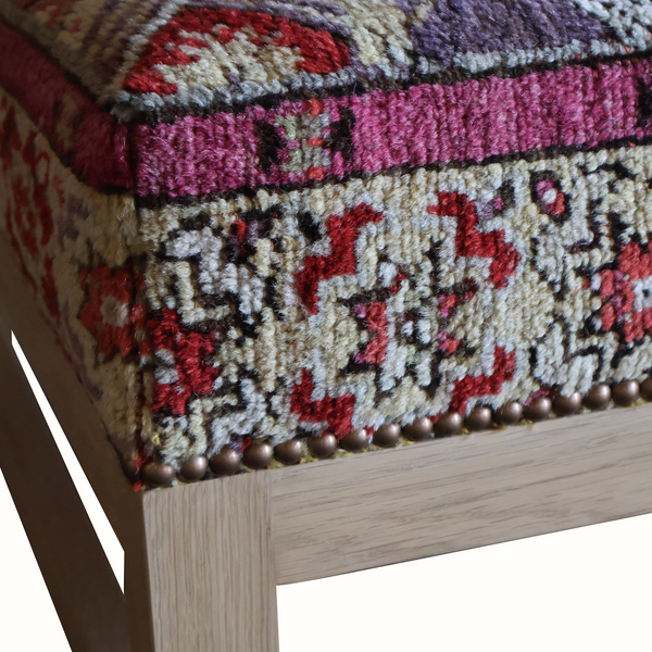 Lexington ottoman close-up of rug-pattern trim with purple border and bead detail