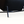 Dark leather lounge chair base with metal legs and black upholstery, close-up underside
