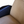Lounge chair corner with dark leather armrest and beige sheepskin cushion, tight close-up