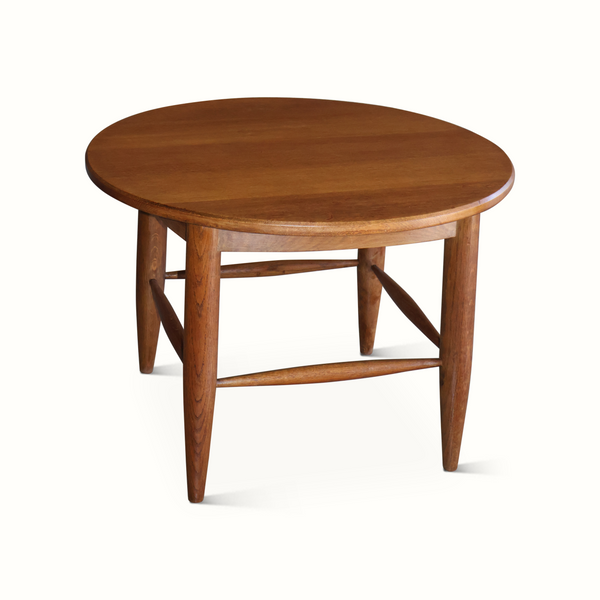 Round dark brown wood side table with tapered legs and cross-brace apron detail