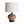 Pottery table lamp featuring a round terracotta ceramic base with carved motif and tan shade
