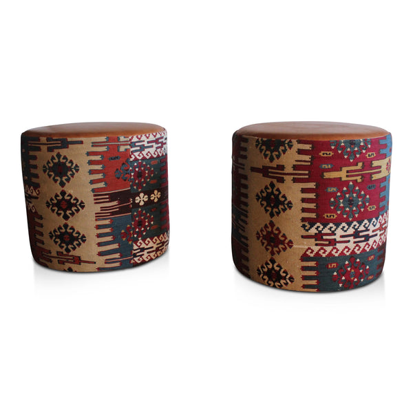 Round kilim pouf with geometric motif in red, navy, cream, and brown with tan top