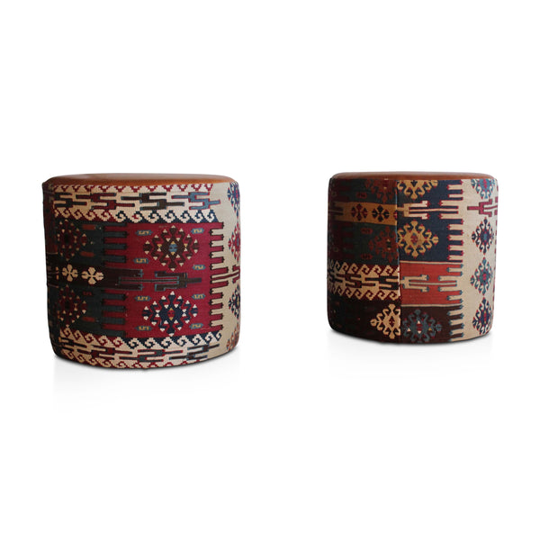 Geometric kilim pouf with red, navy, cream, and brown pattern; tan leather-look top