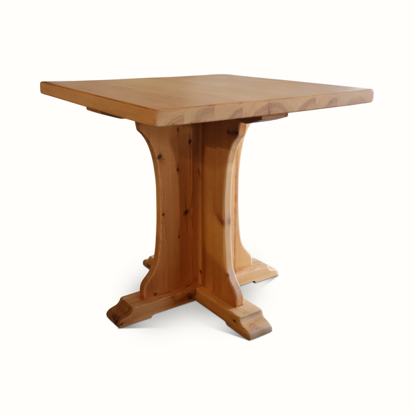 Pine bistro table with square tabletop and turned pedestal legs, light brown wood.