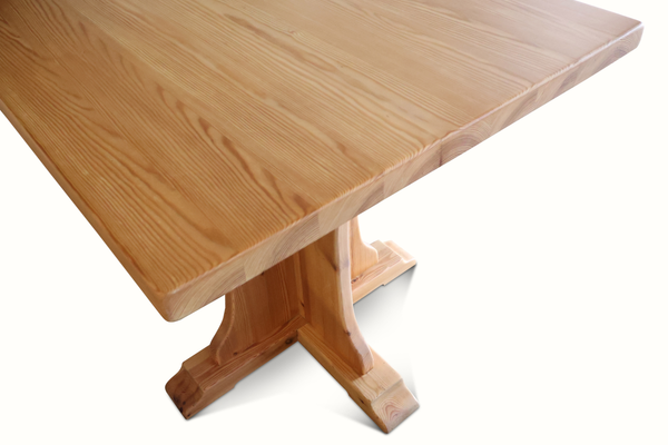 Pine bistro table close-up of square tabletop edge and pedestal leg base, light wood.