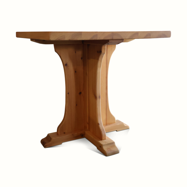 Pine bistro table with carved pedestal leg and square tabletop, light brown wood.