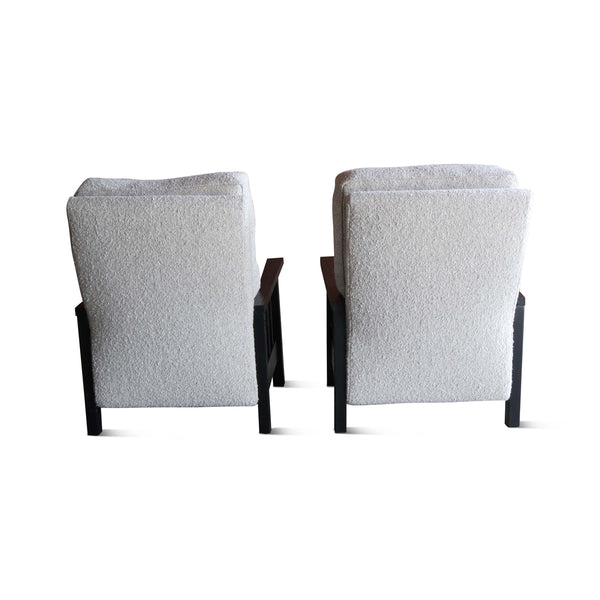 Pair of boucle armchairs with tall light gray back panels and dark wood frames