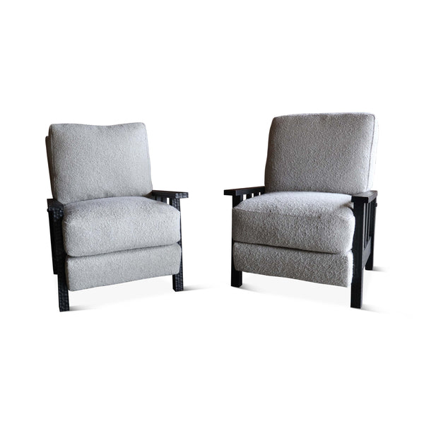 Pair of light gray boucle armchairs with dark wood legs and wide cushioned arms