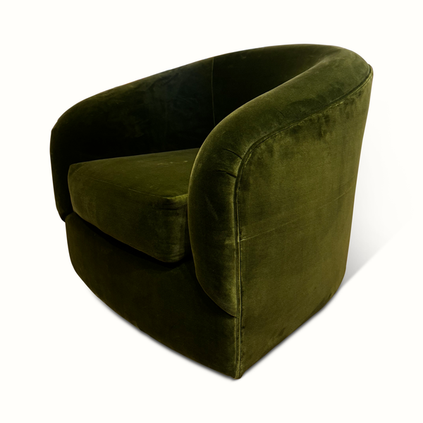 Green velvet swivel chair angled side view with rounded arms and thick seat cushion.