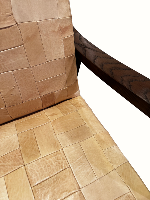 Patchwork leather armchair close-up: tan seat cushion with stitched square patchwork