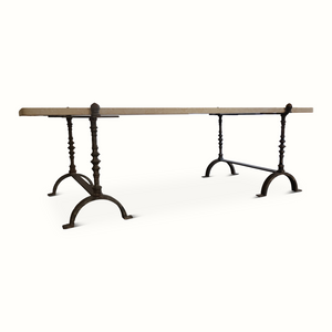 Limestone-topped wrought iron table, side view with arched foot rests and turned legs