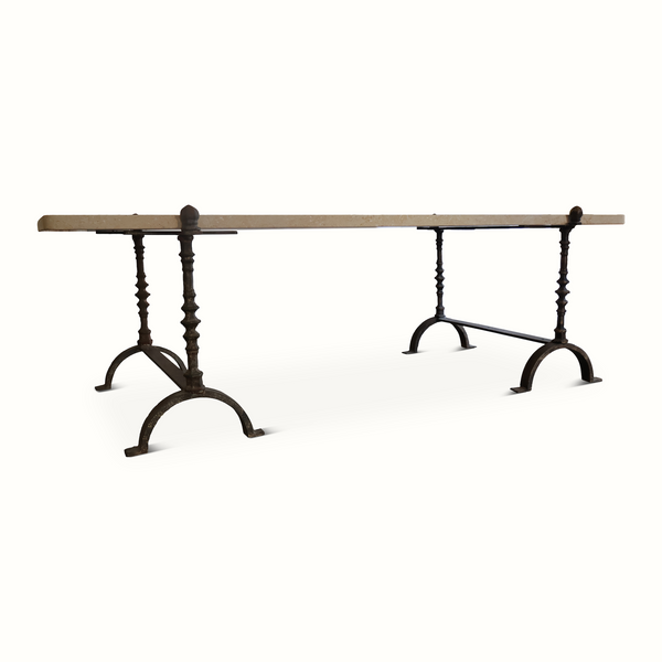 Limestone-topped wrought iron table, side view with arched foot rests and turned legs