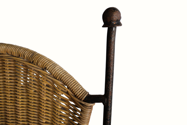 Wicker chair back close-up with dark iron posts and finial tops