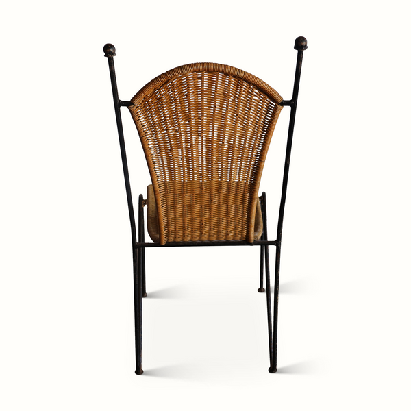Wicker chair with dark iron frame, tall arched back and woven seat