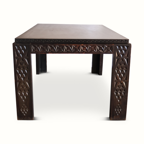 Antique Moroccan table front view with dark carved panels and faceted geometric motifs