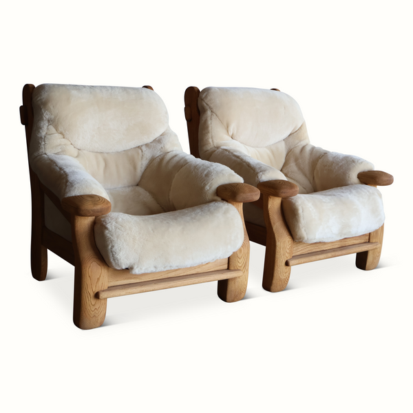 Pair of oak armchairs with light sheepskin upholstery and rounded wooden arms
