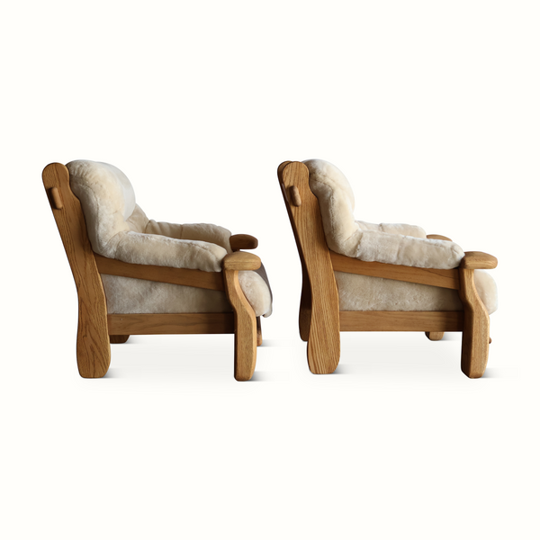 Oak armchairs with light sheepskin upholstery, side profile view