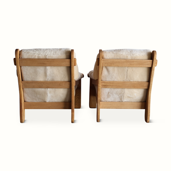 Set of two oak armchairs with light sheepskin upholstery, back view