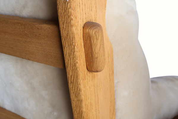 Oak armchair corner and rounded handle with light sheepskin upholstery