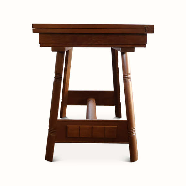 Oak flip-top game table front view with carved panel and lower shelf rail support.