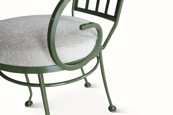 Green metal patio chair arm and circular seat frame with light gray cushion