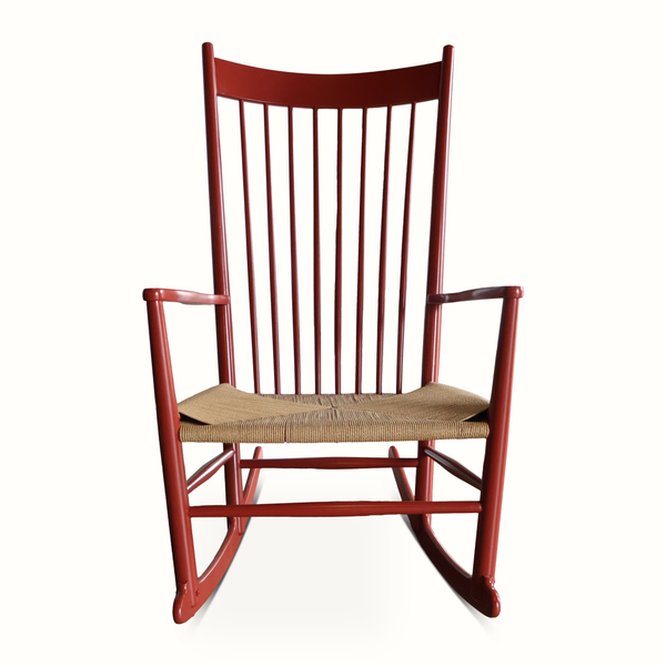 Red wooden rocking chair with slatted back and woven beige seat cushion