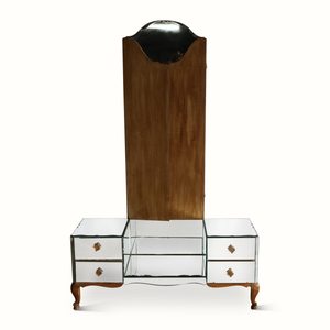 Mirrored vanity table with tall wooden back panel and three glass-front drawer compartments