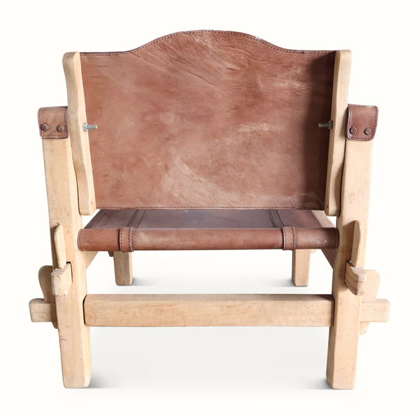 Safari chair front view with brown leather back panel and rolled leather armrests on wood frame