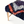 Rug-covered bench end view: navy shag with orange accents and white stripe