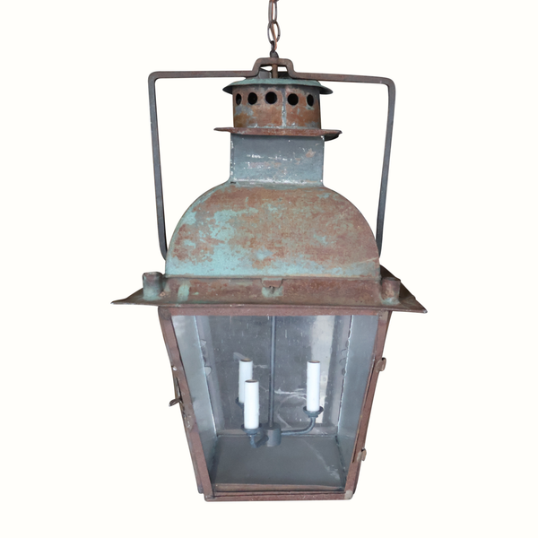 Hanging metal lantern with dome top, clear glass panels, and three white candle sleeves