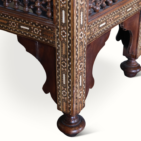 Inlaid Moorish stool base detail with carved panels, geometric inlay, and turned legs