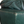 Dark green leather sofa corner detail with visible stitching and creases