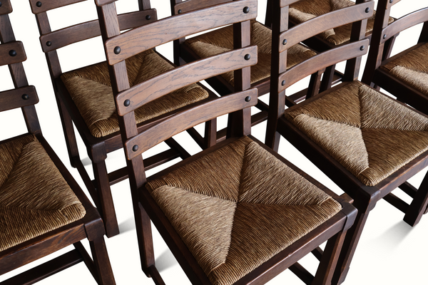 Oak ladderback chair seat detail with woven beige cushion and dark wood slat back.